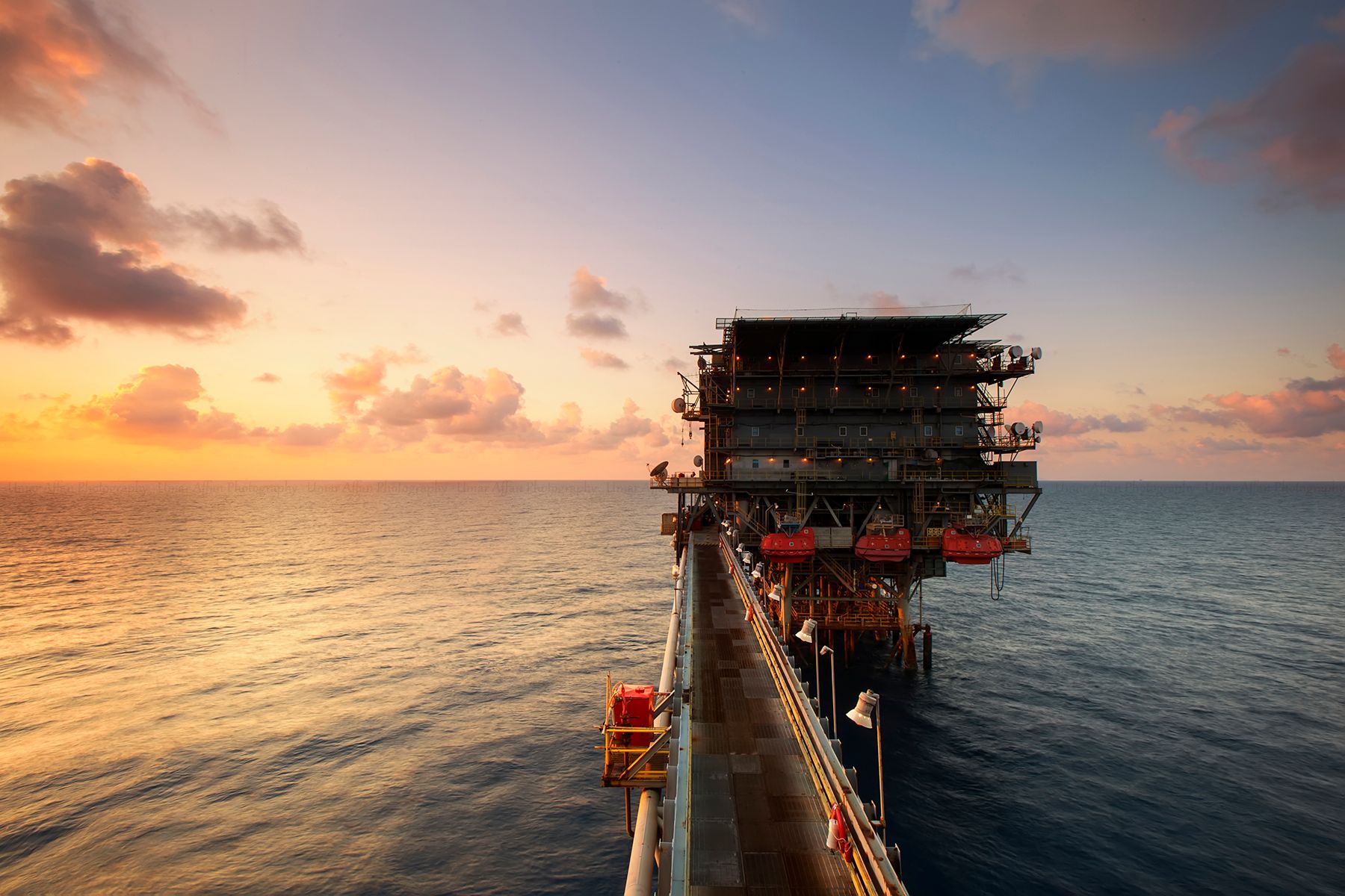 Offshore energy installation silhouetted against the evening sky
